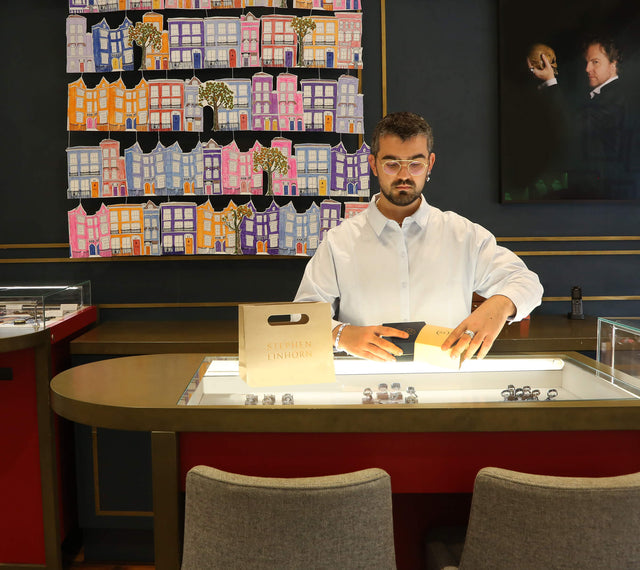 Salesperson packing a piece of jewellery in a jewellery box.